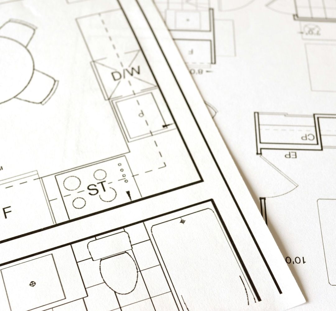 Close-up view of an architectural floor plan on paper showcasing detailed room layouts and measurements.